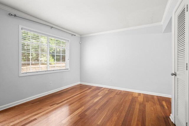 unfurnished bedroom featuring hardwood / wood-style floors, a closet, and ornamental molding