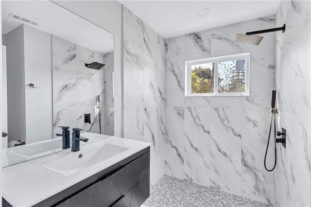 full bath with visible vents, vanity, and a marble finish shower