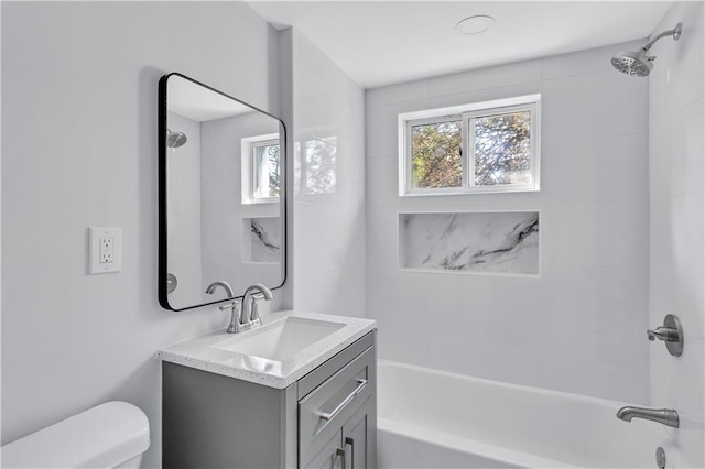 bathroom featuring toilet, vanity, and bathtub / shower combination
