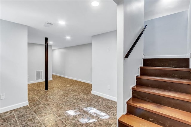 finished below grade area with baseboards, stairs, and visible vents