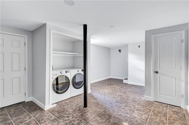 laundry room with baseboards, separate washer and dryer, and laundry area