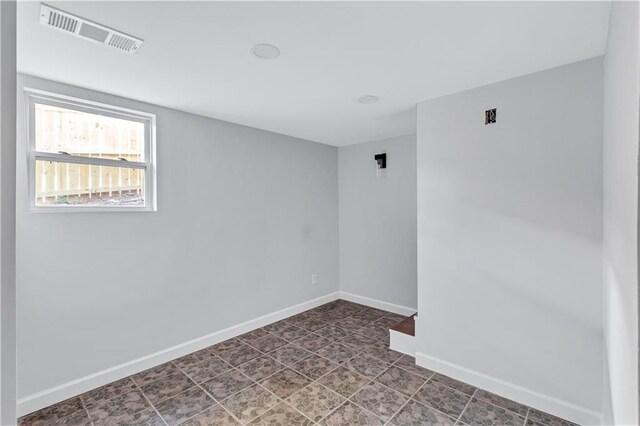 spare room featuring baseboards and visible vents
