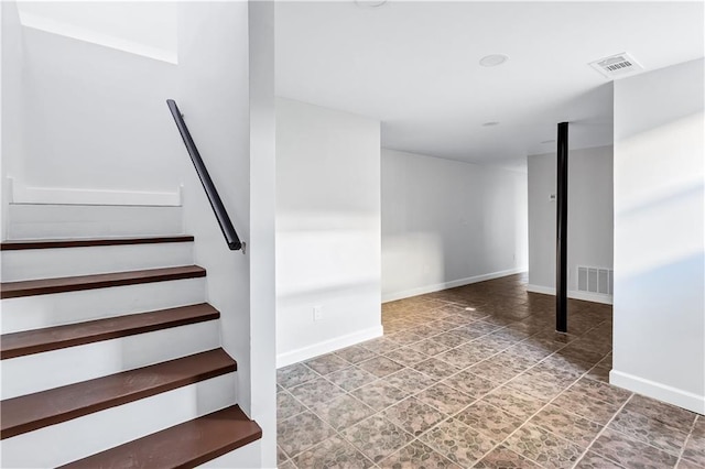 basement with baseboards, stairway, and visible vents