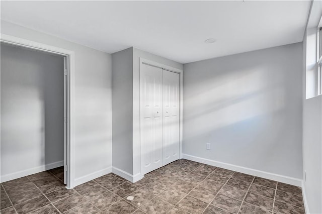 unfurnished bedroom featuring baseboards and a closet