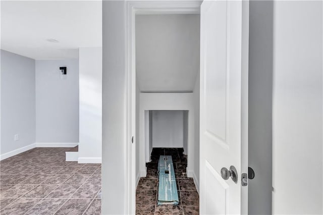 hall with baseboards and tile patterned flooring