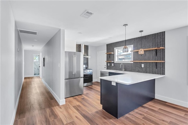 kitchen featuring a sink, appliances with stainless steel finishes, open shelves, and visible vents