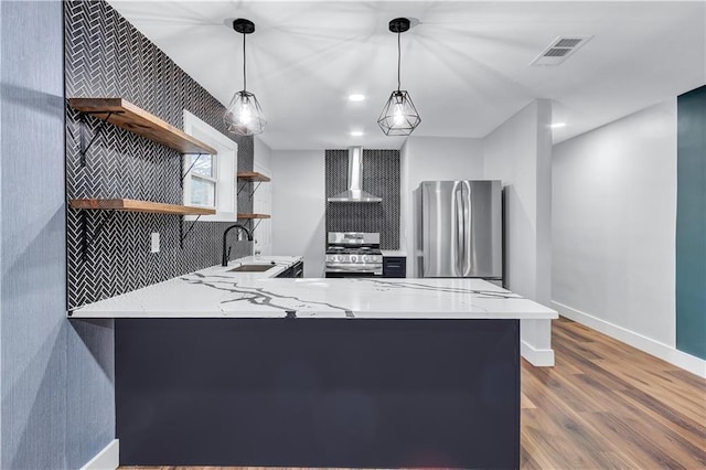 kitchen with open shelves, stainless steel appliances, a sink, wall chimney range hood, and wood finished floors
