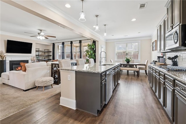 kitchen featuring visible vents, ornamental molding, stainless steel appliances, and a sink