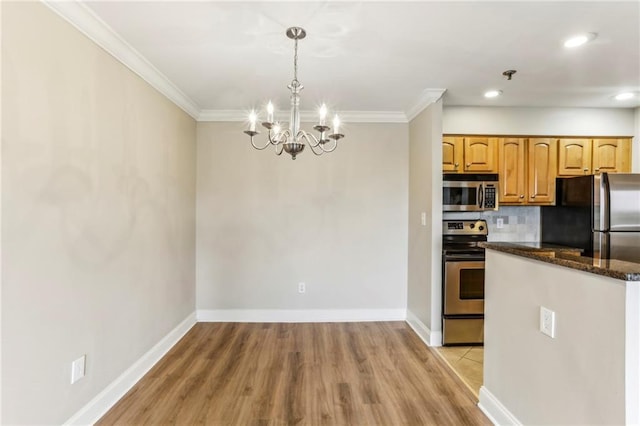 300 Johnson Ferry Rd NE Unit A811, Atlanta, GA 30328 - kitchen with appliances with stainless steel finishes, a chandelier, light wood finished floors, ornamental molding, and tasteful backsplash