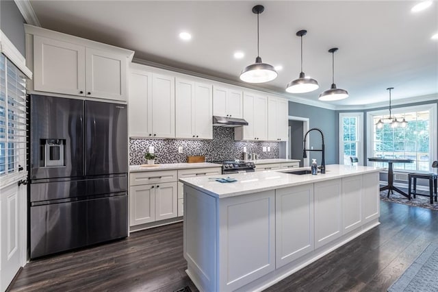 3845 Glen Ian Dr, Loganville, GA 30052 - kitchen featuring stainless steel appliances, a sink, crown molding, dark wood-style flooring, and white cabinetry