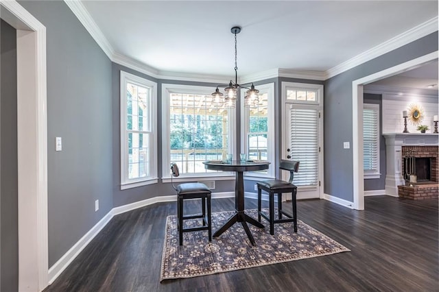 3845 Glen Ian Dr, Loganville, GA 30052 - dining room with wood finished floors, a chandelier, baseboards, crown molding, and a fireplace