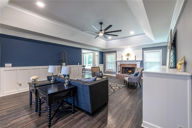 3845 Glen Ian Dr, Loganville, GA 30052 - living room with a tray ceiling, a ceiling fan, dark wood-type flooring, a brick fireplace, and recessed lighting