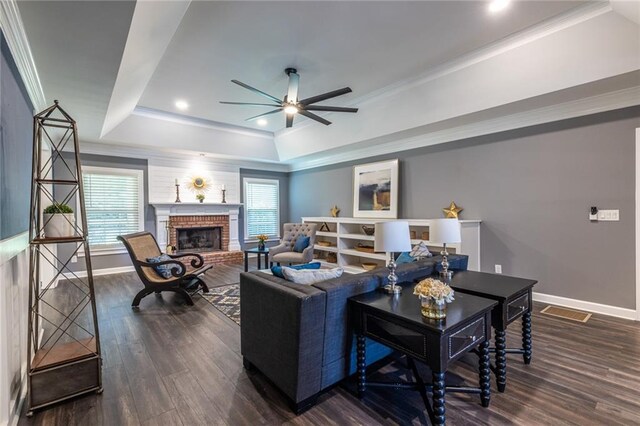 3845 Glen Ian Dr, Loganville, GA 30052 - living area featuring a tray ceiling, ceiling fan, baseboards, wood finished floors, and a brick fireplace