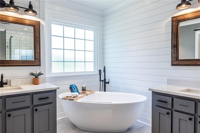 3845 Glen Ian Dr, Loganville, GA 30052 - bathroom with healthy amount of natural light, a freestanding bath, ornamental molding, two vanities, and wood walls