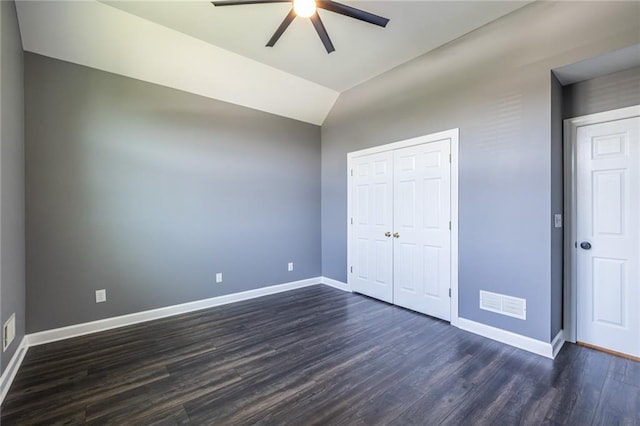 3845 Glen Ian Dr, Loganville, GA 30052 - unfurnished bedroom featuring baseboards, dark wood-type flooring, lofted ceiling, a closet, and a ceiling fan
