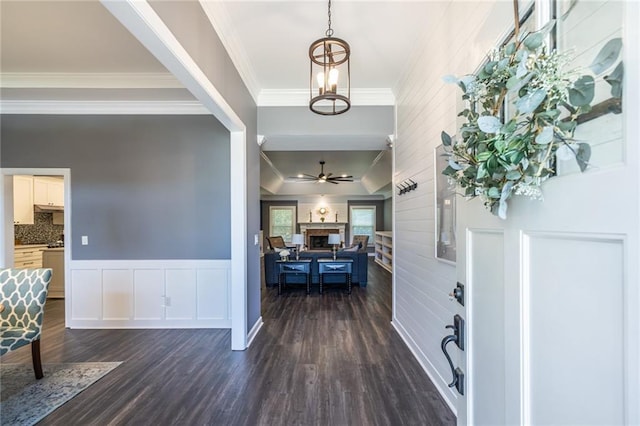 3845 Glen Ian Dr, Loganville, GA 30052 - entryway with ornamental molding, dark wood-type flooring, a fireplace, a ceiling fan, and a chandelier
