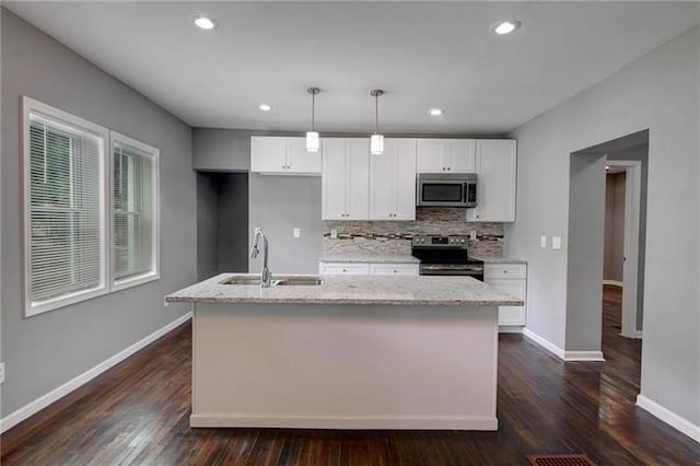 kitchen with dark hardwood / wood-style flooring, stainless steel appliances, sink, white cabinetry, and an island with sink