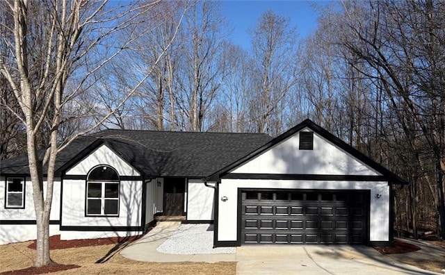 view of front of home with a garage, concrete driveway, and a shingled roof