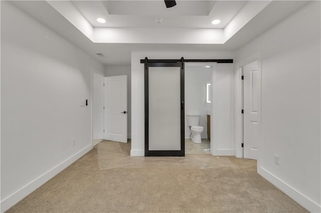 2358 Tilson Rd, Decatur, GA 30032 - unfurnished bedroom with a barn door, light colored carpet, recessed lighting, ensuite bath, and a raised ceiling