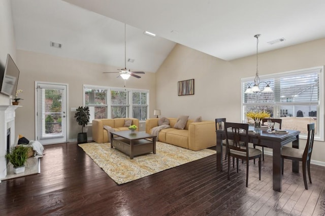 living room with lofted ceiling, ceiling fan with notable chandelier, and dark hardwood / wood-style floors