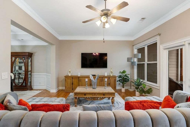 living room with ornamental molding, ceiling fan, and light wood-type flooring