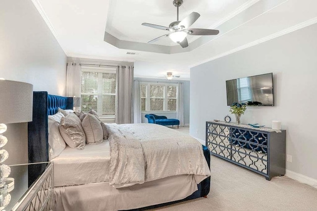 bedroom featuring ceiling fan, ornamental molding, a raised ceiling, and light colored carpet