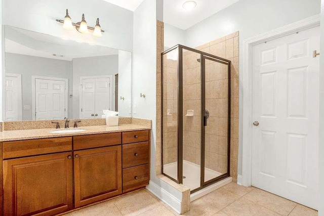 bathroom featuring vanity, a shower with shower door, and tile patterned floors