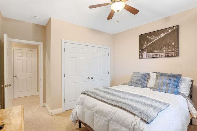 bedroom featuring light carpet, a closet, and ceiling fan