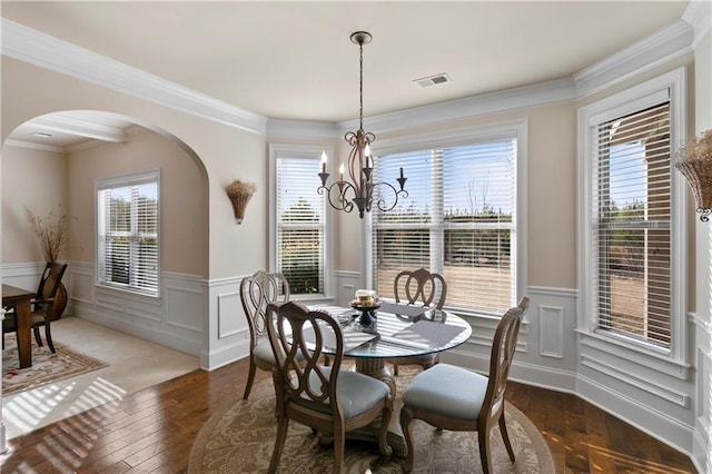 1307 Clarecastle Ln, Buford, GA 30519 - dining space featuring arched walkways, wainscoting, a chandelier, wood-type flooring, and ornamental molding