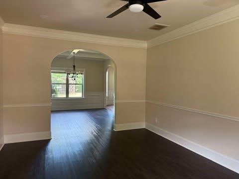 1307 Clarecastle Ln, Buford, GA 30519 - empty room with arched walkways, ornamental molding, dark wood-type flooring, a chandelier, and baseboards
