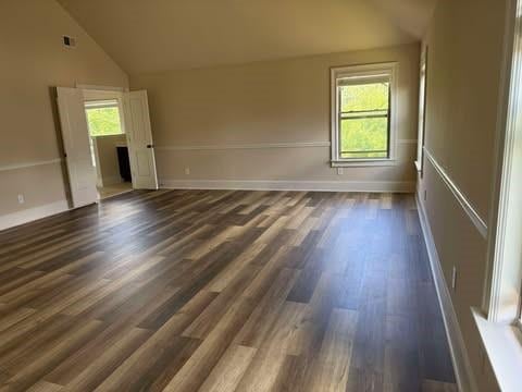 1307 Clarecastle Ln, Buford, GA 30519 - spare room featuring vaulted ceiling, dark wood-style flooring, and baseboards