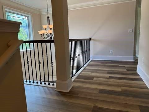 1307 Clarecastle Ln, Buford, GA 30519 - stairway with wood finished floors, a chandelier, ornamental molding, and baseboards