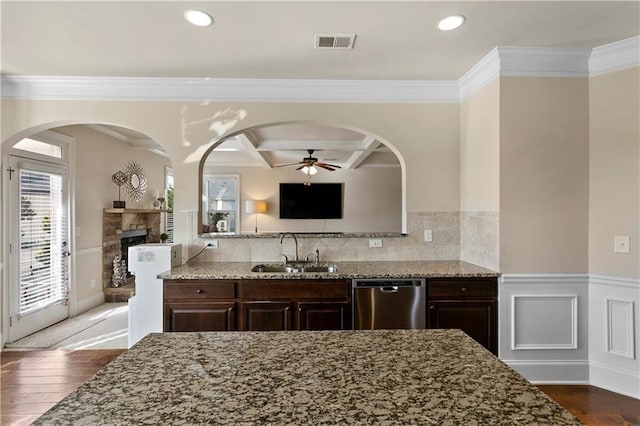 1307 Clarecastle Ln, Buford, GA 30519 - kitchen with stainless steel dishwasher, a sink, dark brown cabinetry, ceiling fan, and light stone counters