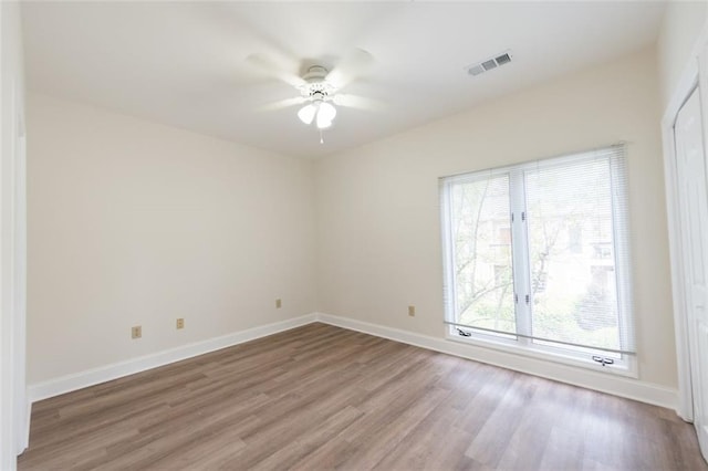 empty room with hardwood / wood-style floors and ceiling fan