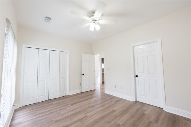 unfurnished bedroom featuring ceiling fan, light wood-type flooring, and a closet