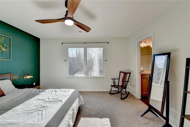 carpeted bedroom with visible vents, ceiling fan, ensuite bath, and baseboards