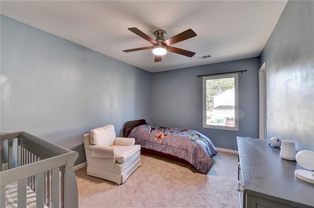 bedroom featuring baseboards, ceiling fan, visible vents, and light colored carpet