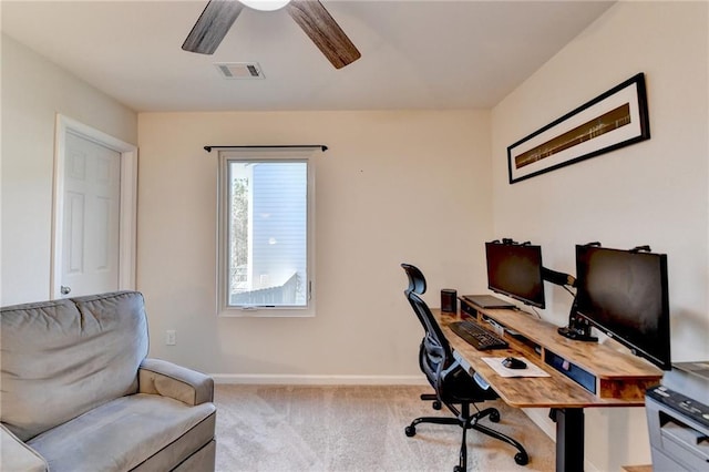 office area with baseboards, visible vents, ceiling fan, and light colored carpet