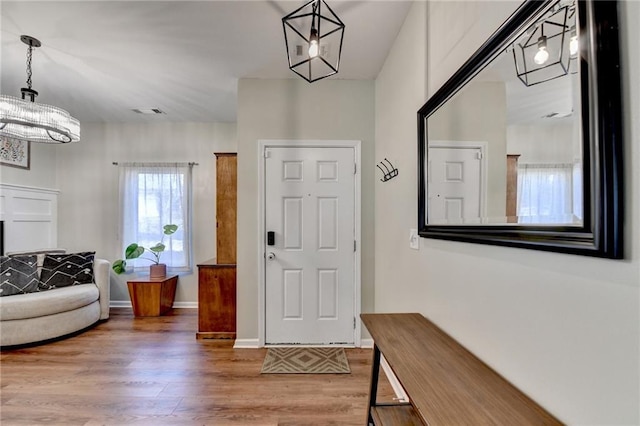 foyer featuring wood finished floors, visible vents, and baseboards