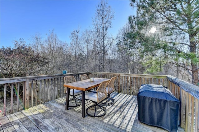 wooden deck with outdoor dining space and grilling area