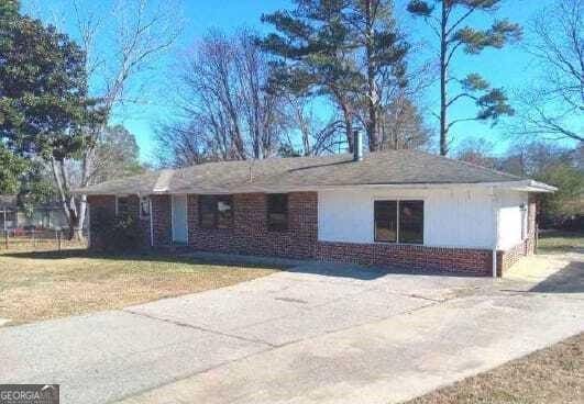 view of home's exterior with brick siding and a lawn