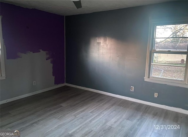 unfurnished room with baseboards and wood finished floors