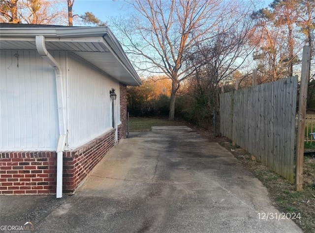 view of home's exterior with brick siding and fence