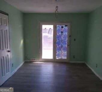 unfurnished dining area with baseboards and wood finished floors