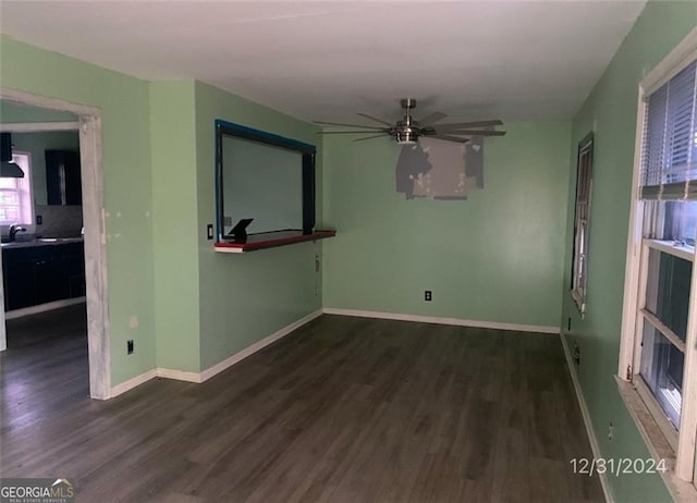 unfurnished living room with a sink, baseboards, wood finished floors, and a ceiling fan