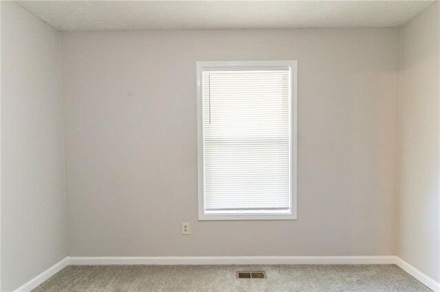unfurnished room featuring baseboards, carpet, and visible vents