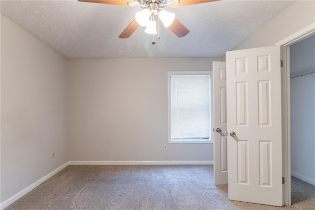 unfurnished bedroom with baseboards, ceiling fan, light carpet, and a textured ceiling