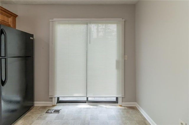 interior space with light tile patterned floors, baseboards, and visible vents