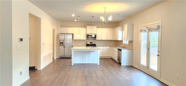 133 Wayside Ter, Braselton, GA 30517 - kitchen with stainless steel appliances, a sink, decorative backsplash, a chandelier, and white cabinets