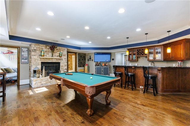 playroom featuring a fireplace, hardwood / wood-style floors, ornamental molding, sink, and pool table